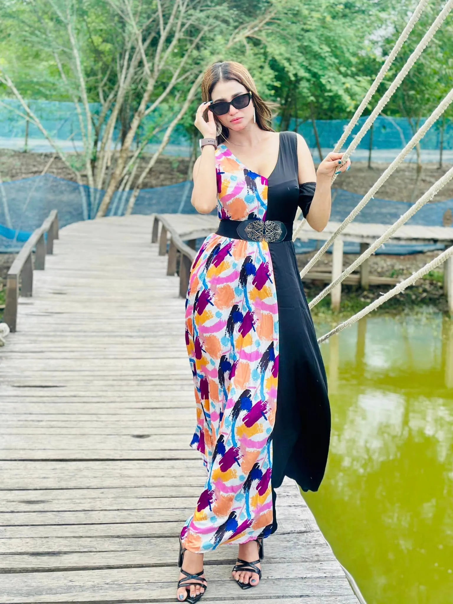 Woman in a colorful dress standing on a wooden bridge by a pond - BlackBole High Quality Western Dress