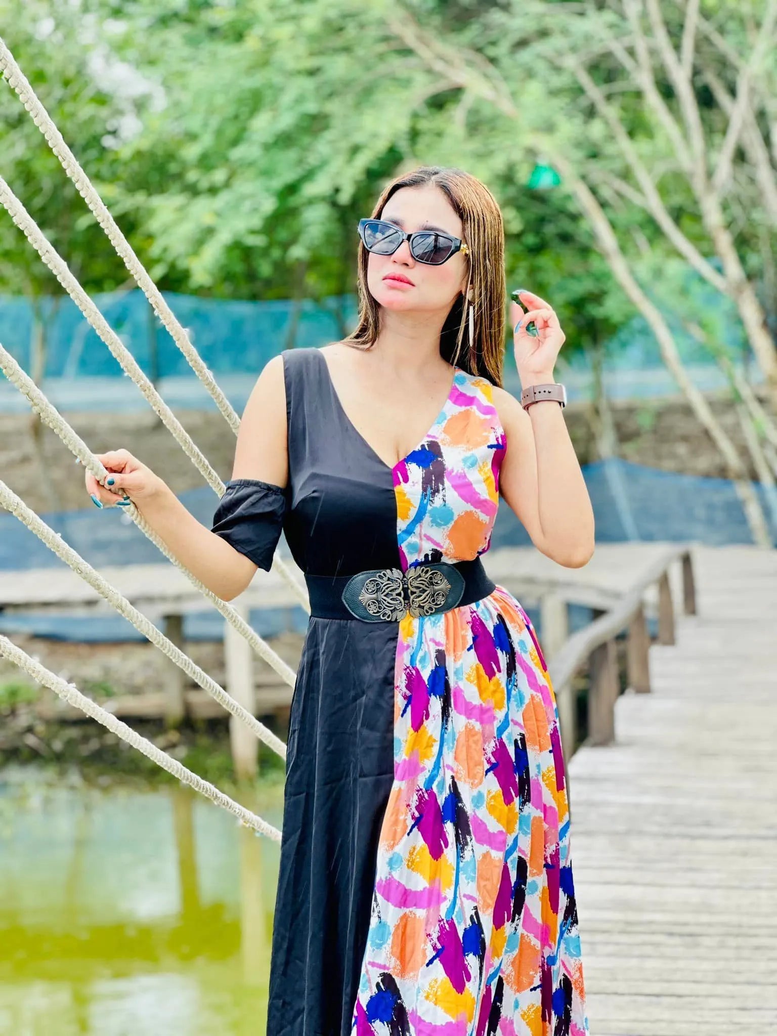 Woman wearing a black dress with a colorful floral pattern over it, standing outdoors near a body of water - BlackBole High Quality Western Dress