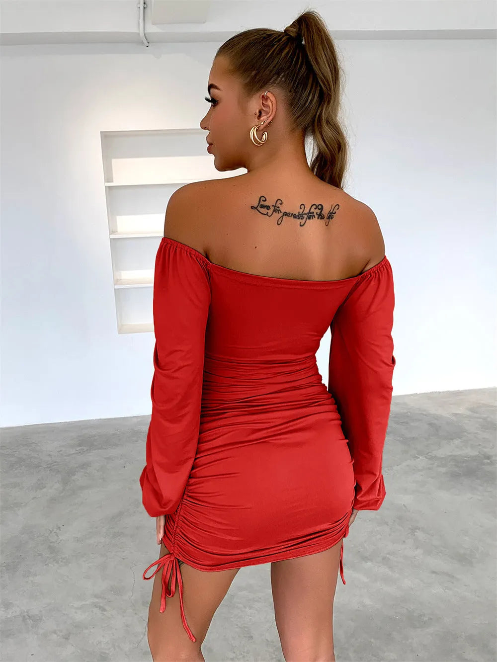 Woman in a red off-shoulder dress with a tattoo on her back, standing against a white wall - BlackBole High Quality Western Dress