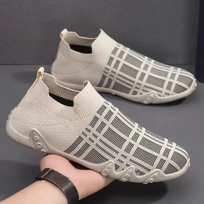 White slip-on sneakers with black grid pattern worn by a person on a gray background - BlackBole High Quality Shoe