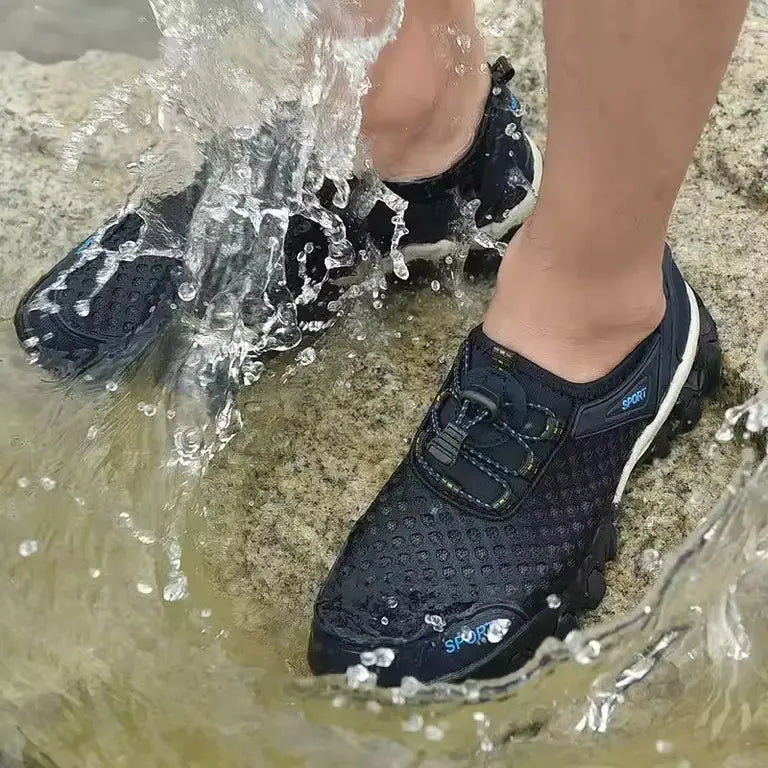 Person wearing navy blue athletic shoes with white soles walking through water- BlackBole High Quality Shoe