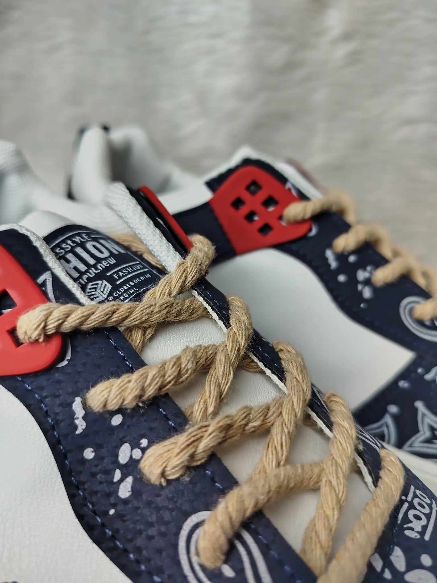 Close-up of a sneaker with braided laces on a gray surface - BlackBole High Quality Watch