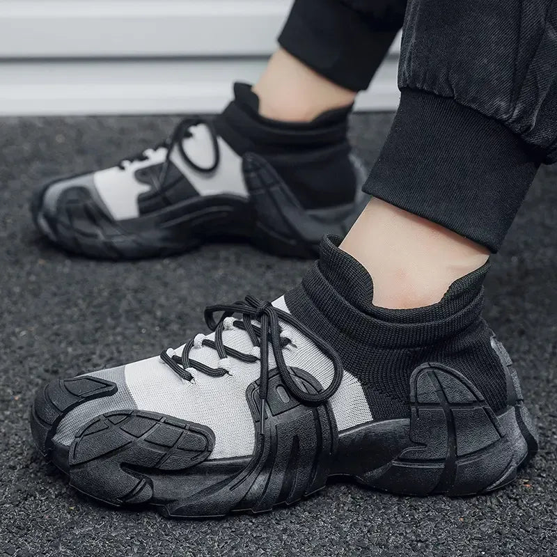 Black and gray athletic shoes worn on a person's feet with a blurred background - BlackBole High Quality Shoe