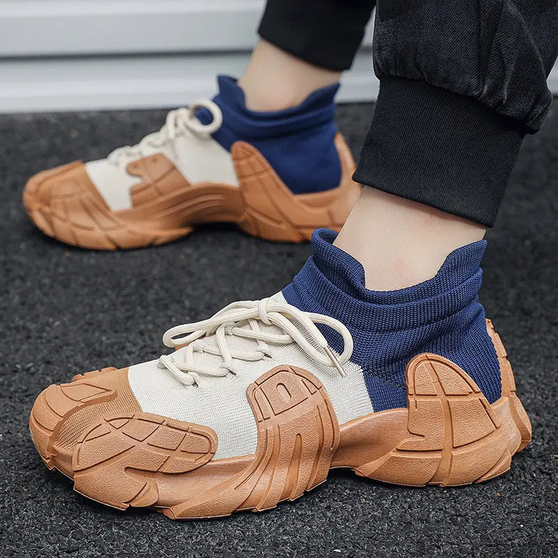 A pair of high-performance sneakers with beige, blue, and brown colors. The shoes have a rugged texture and are displayed alongside a white box with a logo and a brown surface - BlackBole High Quality Shoe