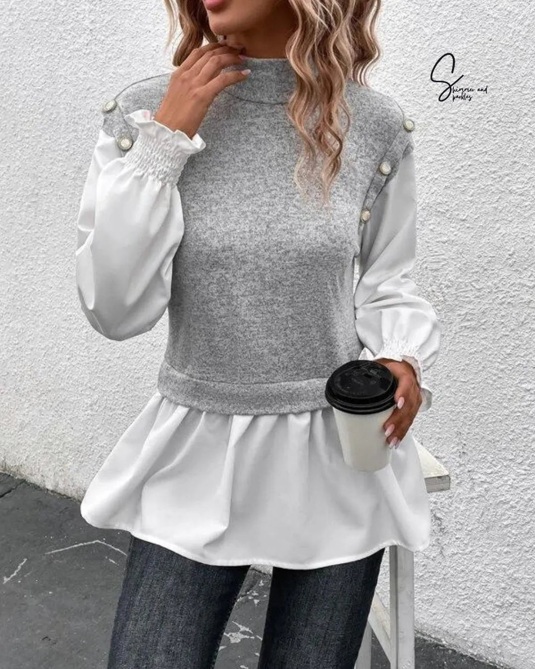 Woman wearing a gray and white long-sleeve top with pearl details, holding a coffee cup against a light gray wall - BlackBole High Quality Western Dress
