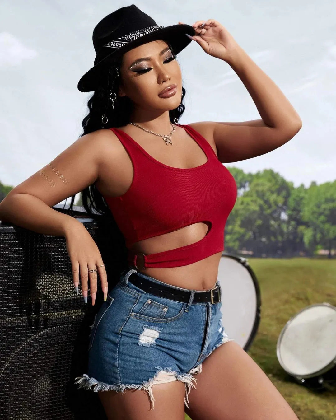 Woman wearing a red crop top and denim shorts with a black hat outdoors - BlackBole High Quality Western Dress