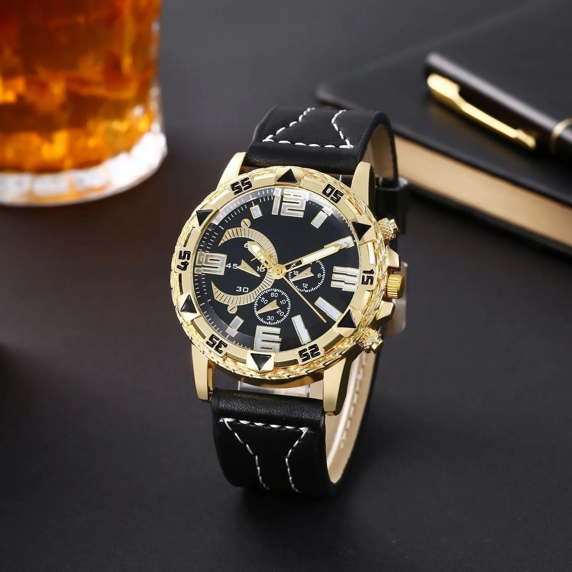 Gold watch with black leather strap on a dark surface with a glass of tea and notebook - BlackBole High Quality Watch
