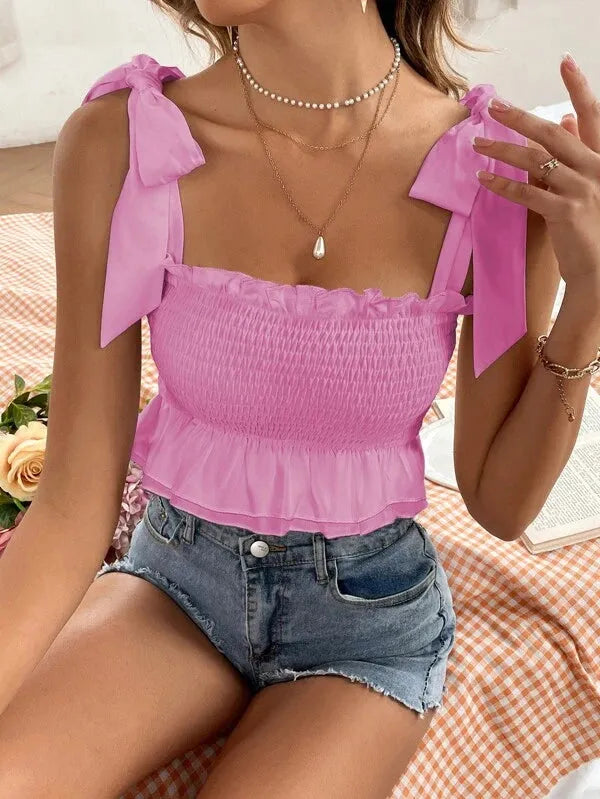 Woman wearing a pink top with bow straps and denim shorts, sitting on a checkered surface - BlackBole High Quality Western Dress