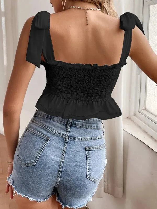 Person wearing a black top with bow straps and denim shorts indoors - BlackBole High Quality Western Dress