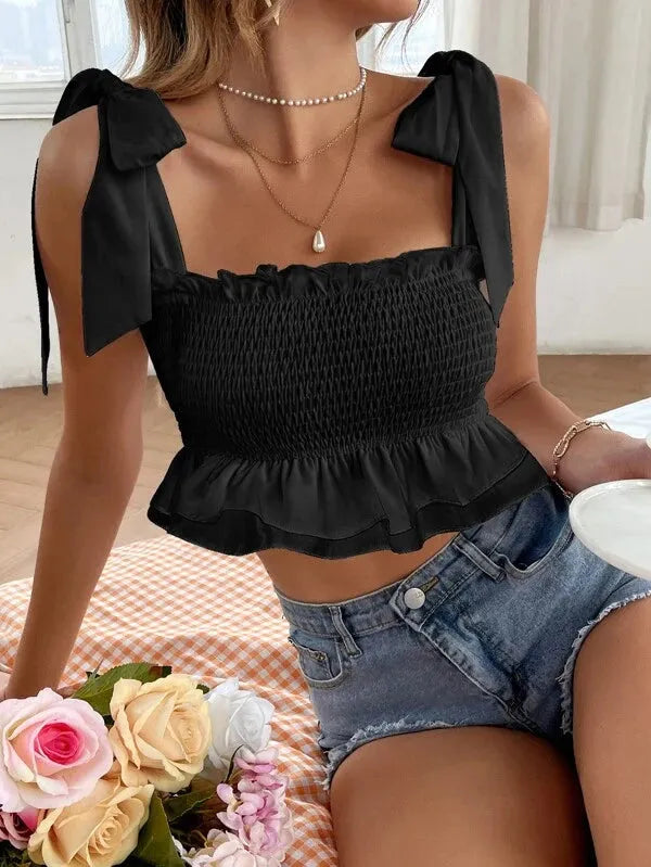 Person wearing a black top with bow straps and denim shorts, sitting on a couch with flowers in the foreground - BlackBole High Quality Western Dress