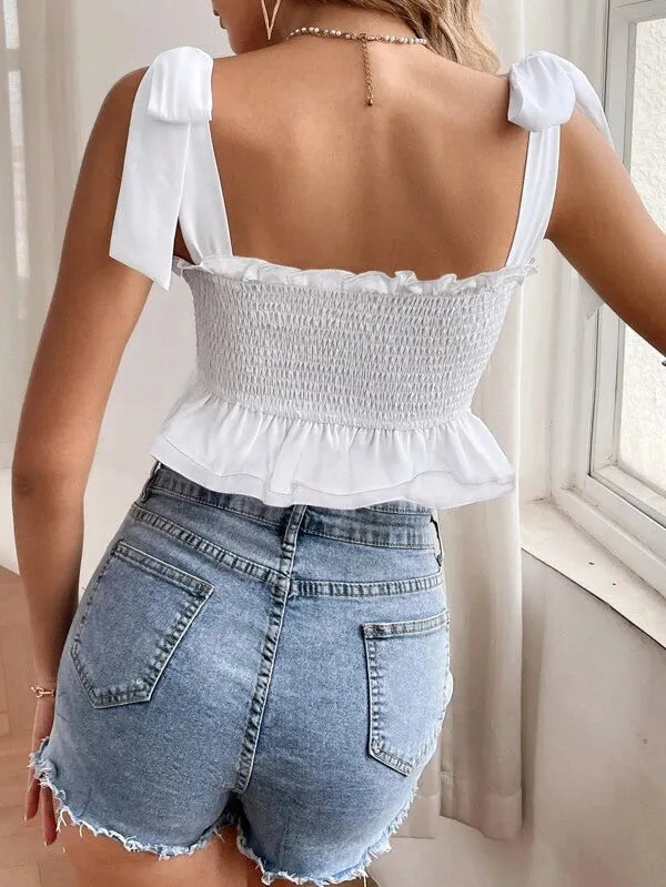 Woman wearing a white top with bow straps and denim shorts indoors - BlackBole High Quality Western Dress