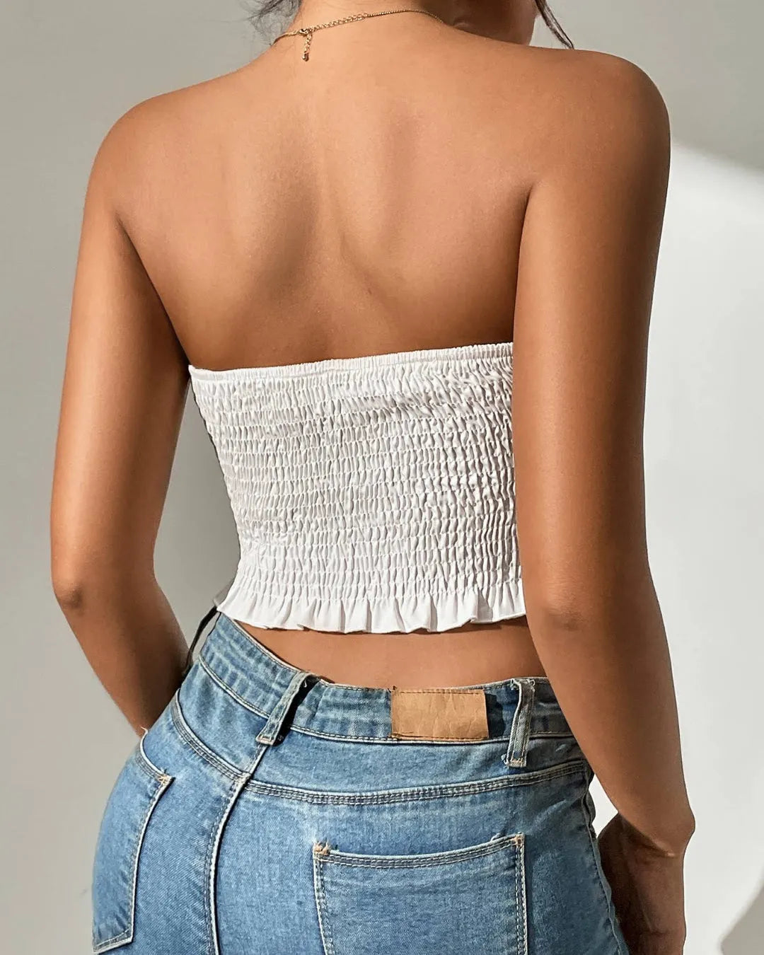 Person wearing a white strapless top and blue jeans against a neutral  - BlackBole High Quality Western Dressbackground